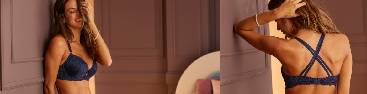 Vrouw in bh die tegen de muur aanstaat