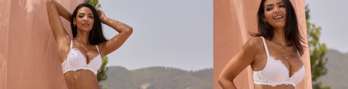 Vrouw in bh die buiten tegen de muur aan staat